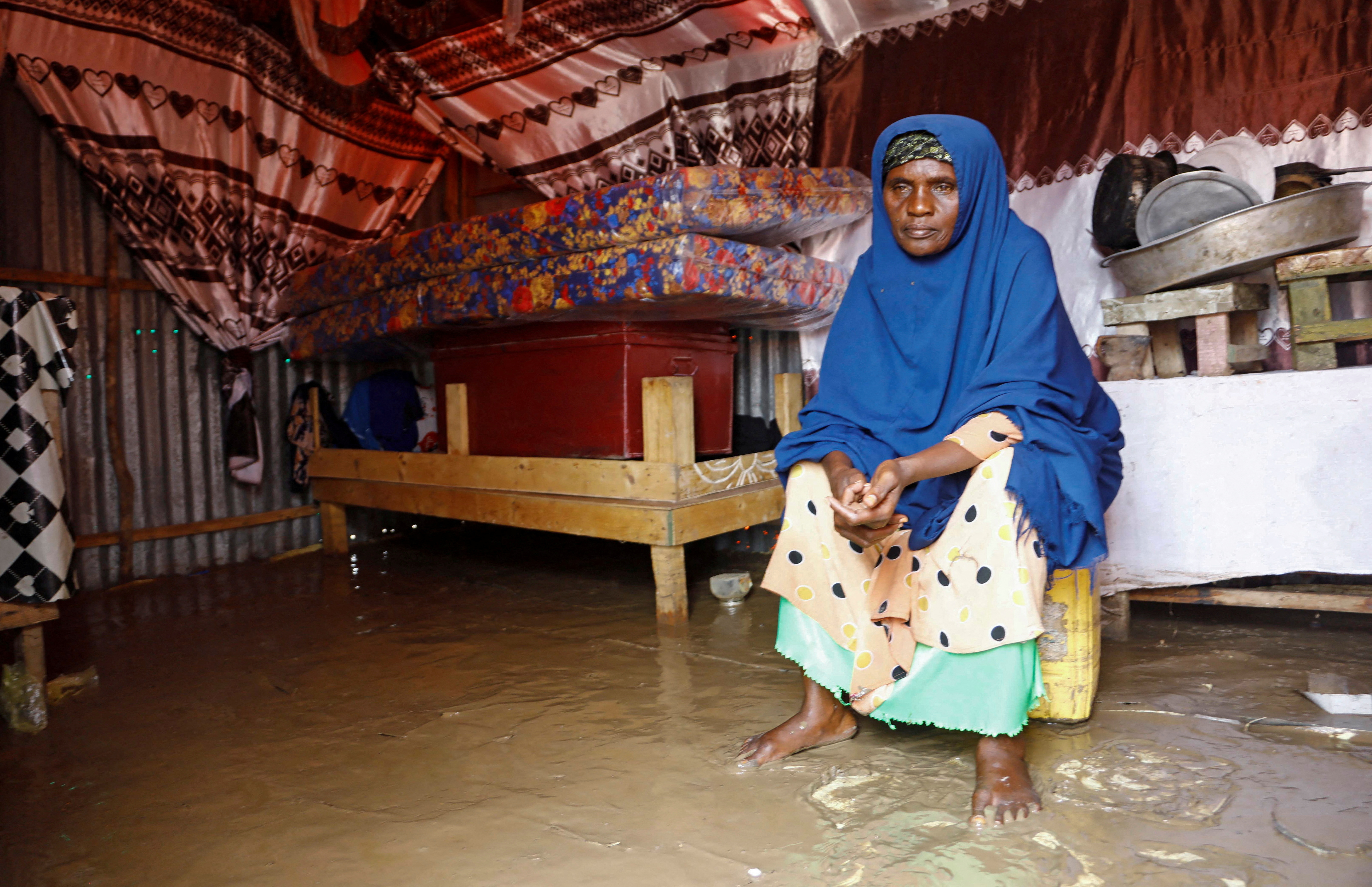 Mulher somali deslocada senta dentro de abrigo improvisado inundado nos arredores de Mogadício
