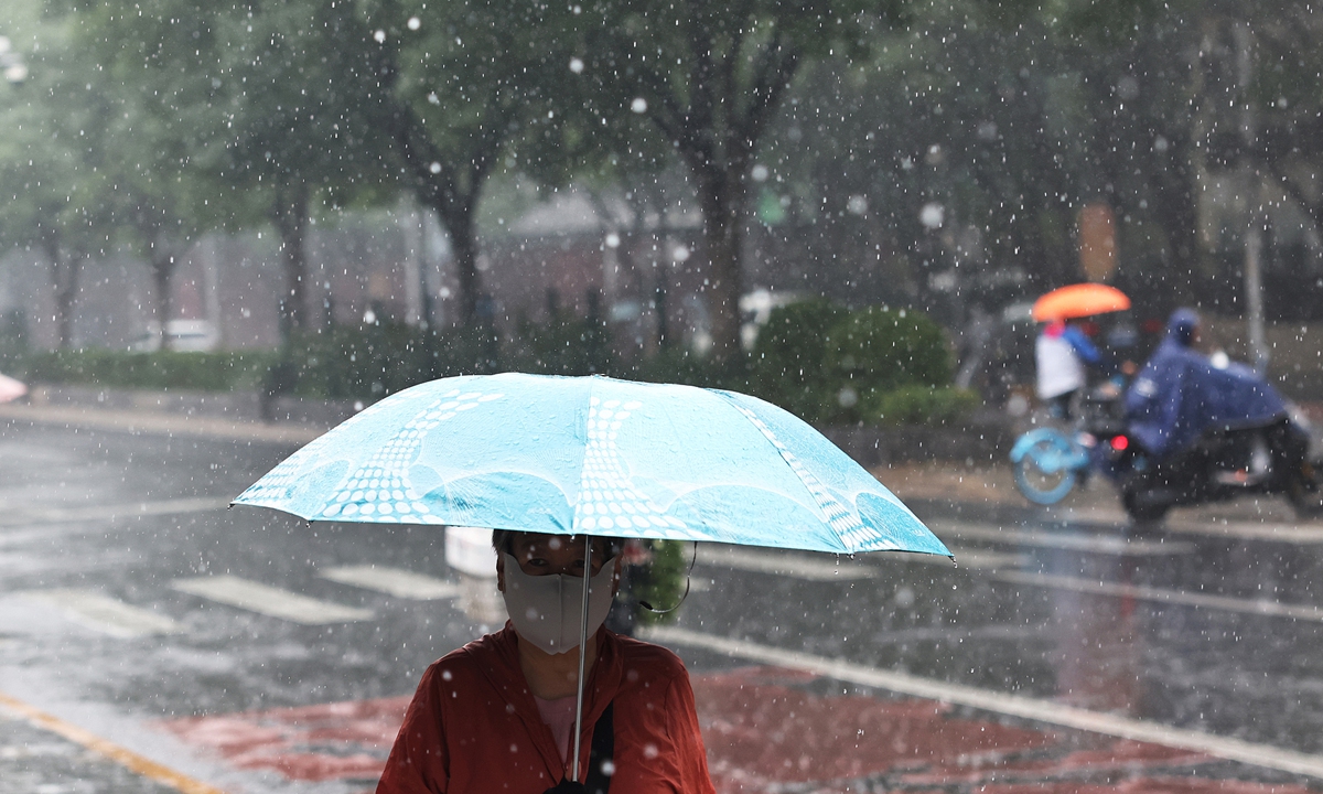 Moradores de Pequim sob chuva intensa