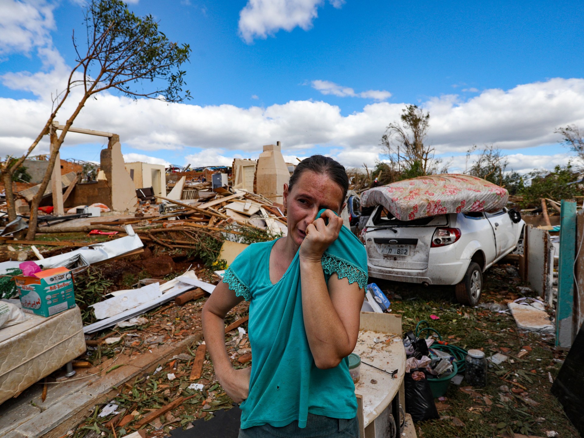 Moradora chora sobre os escombros de sua casa destruída por tornado em Rio Bonito do Iguaçu, Paraná