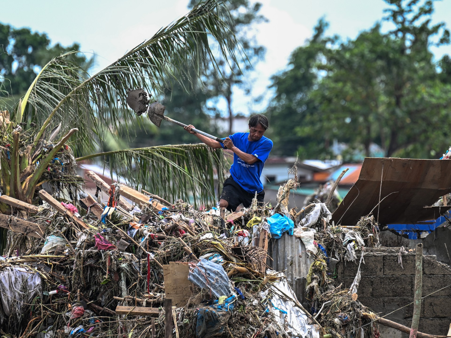 Moradores limpam casas danificadas em Talisay, província de Cebu, após o tufão Kalmaegi
