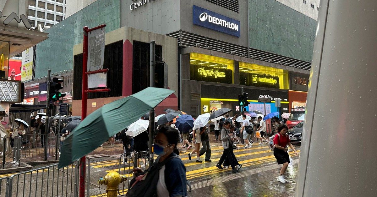 Pedestres em Hong Kong sob chuva e vento na véspera do tufão Noul