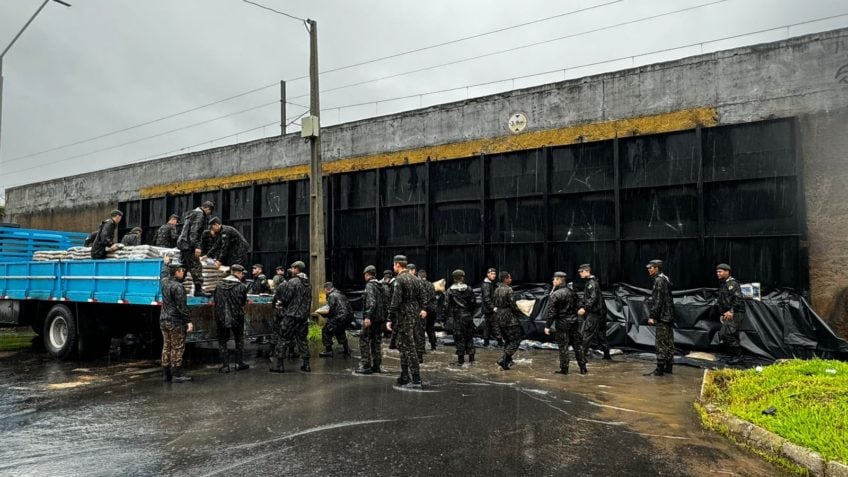 Militares e bombeiros usam sacos de areia para tentar vedar comportas do sistema de proteção contra cheias de Porto Alegre