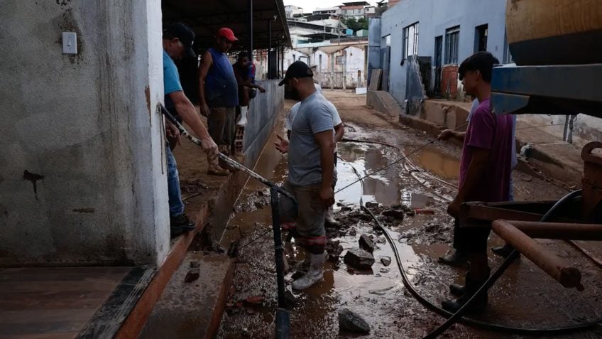 Pessoas recolhem pertences após chuvas intensas no Brasil