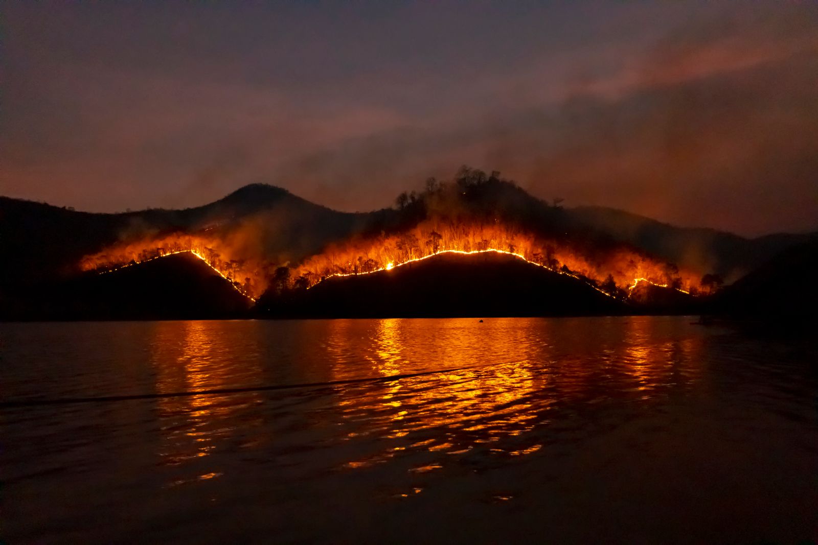 Incêndio florestal visto de encosta de montanha