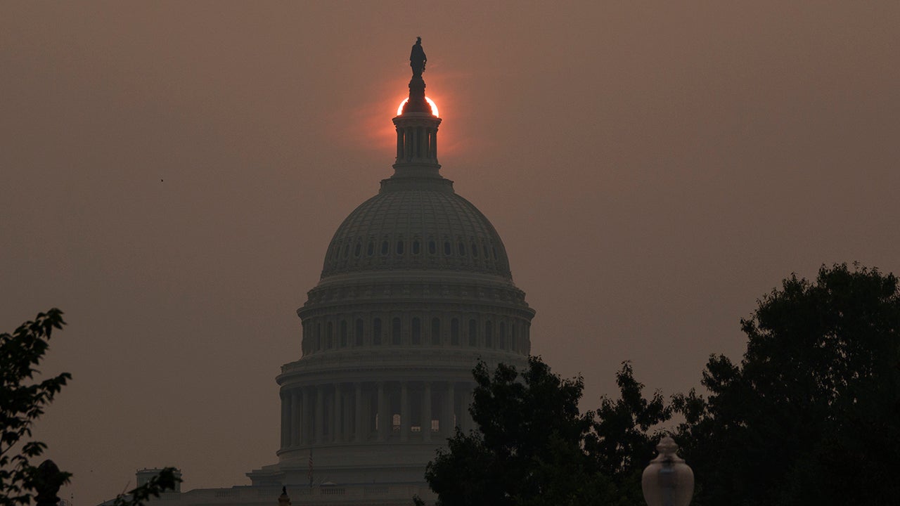 Sol nasce encoberto pela fumaça sobre o Capitólio, em Washington